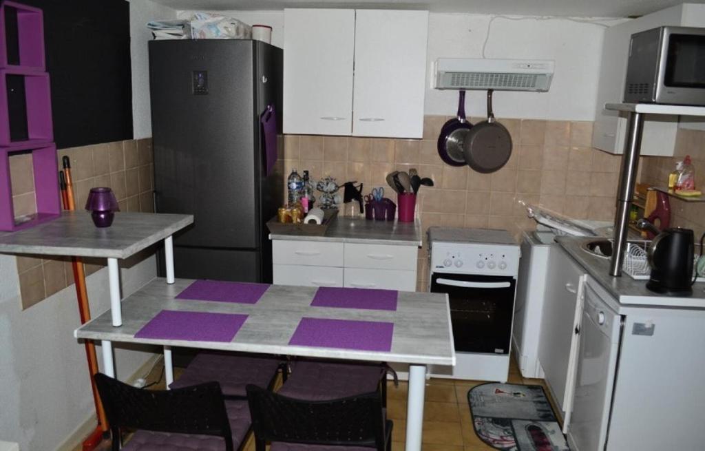 une cuisine avec une table avec des tapis violets dessus dans l'établissement Résidence Grande Bleue - VILLA 3 PIECES 6 couchages PORT LEUCATE MAE-4804, à Port-Leucate