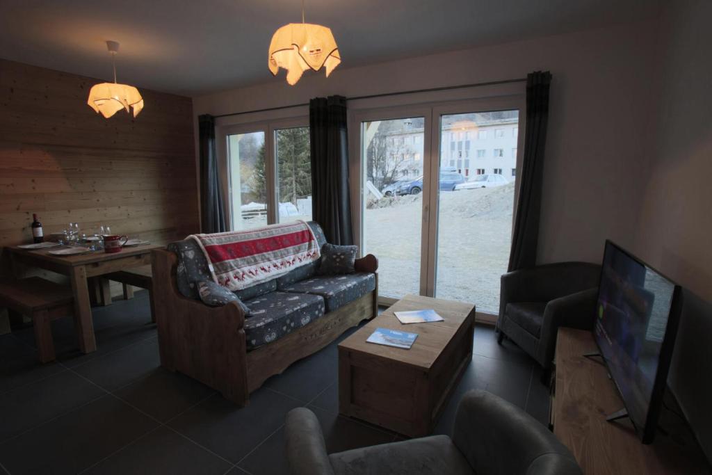 a living room with a couch and a tv at Les Chalets Du Grand Galibier - 3 Pièces pour 4 Personnes 44 in Valloire