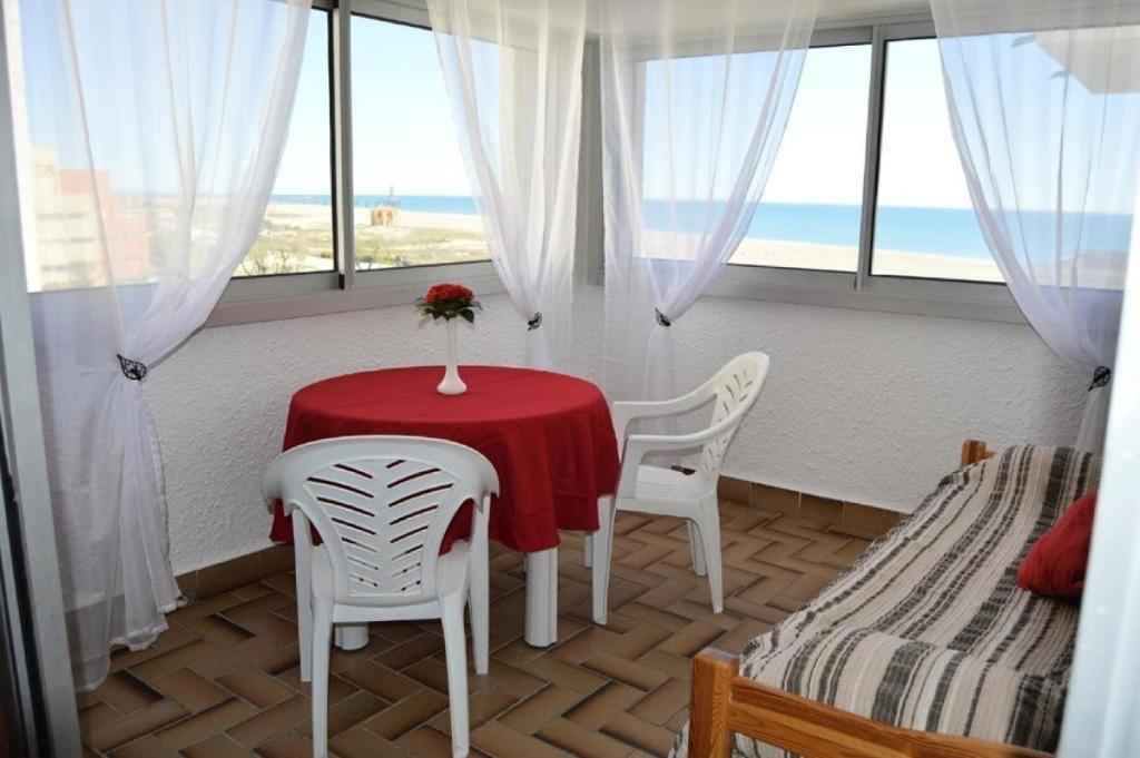 une pièce avec une table et deux chaises et une fenêtre dans l'établissement Résidence Les Cyclades - STUDIO 4 PERSONNES 4 couchages PORT LEUCATE. Réf: 2CYC_38A MAE-4884, à Port-Leucate