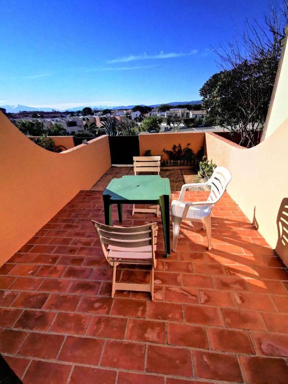 d'une terrasse avec une table et des chaises sur un sol en briques. dans l'établissement Résidence Maisons De La Mer 2 - Joli studio pour 3 personnes avec terrasse en rez de chaussée à Port Leucate. Réf: 1MM2_239 MAE-4984, à Port-Leucate