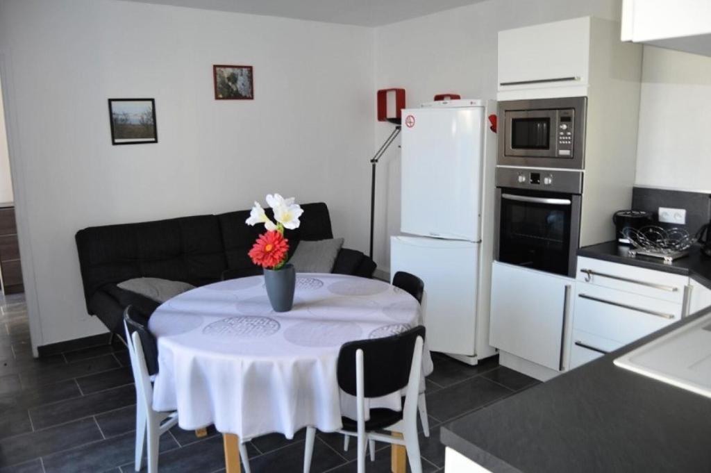 une cuisine avec une table avec un vase de fleurs dessus dans l'établissement Résidence Le Cap De Front - VILLA 3 PIECES 6 couchages PORT LEUCATE MAE-5314, à Port-Leucate