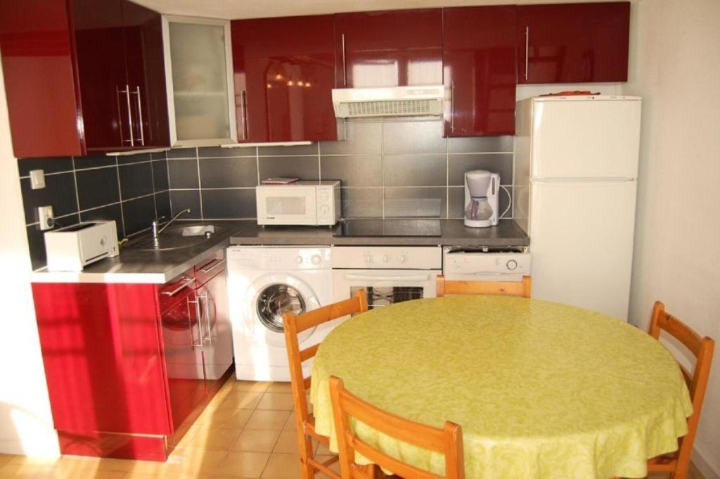 une cuisine avec une table et un réfrigérateur blanc dans l'établissement Résidence Grande Bleue - VILLA 3 PIECES 6 couchages PORT LEUCATE MAE-5334, à Port-Leucate