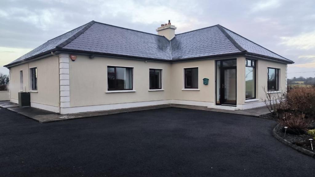 a detached house with a driveway at Swinford Country House in Swinford