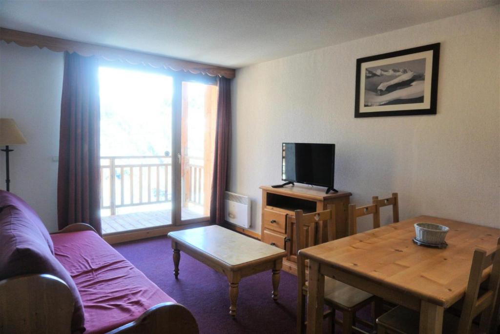 un salon avec un canapé, une table et une télévision dans l'établissement Résidence Cristallines - 3 Pièces 6 Personnes MAE-2454, à Orcières