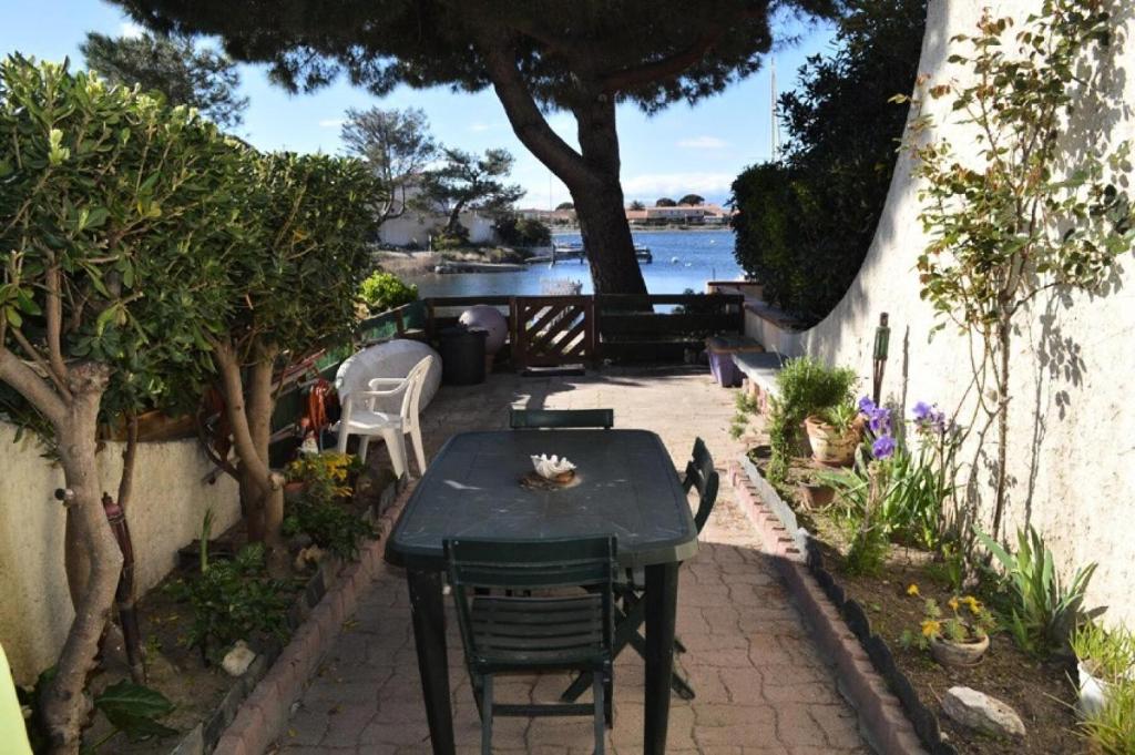 d'une terrasse avec une table et des chaises au bord de l'eau. dans l'établissement Résidence Marina Plage - VILLA T2 MEZZANINE 6 couchages PORT LEUCATE MAE-5354, à Port-Leucate