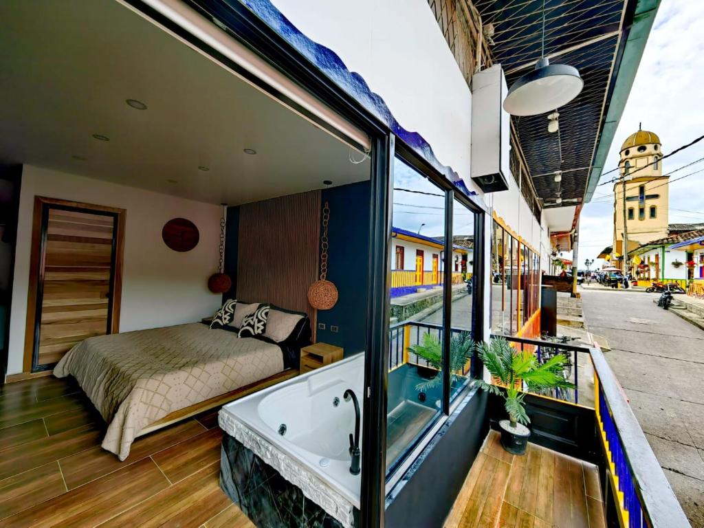 a room with a bed and a bath tub at Habitacion Deluxe 2 con Jacuzzi a 20 mt del parque in Salento