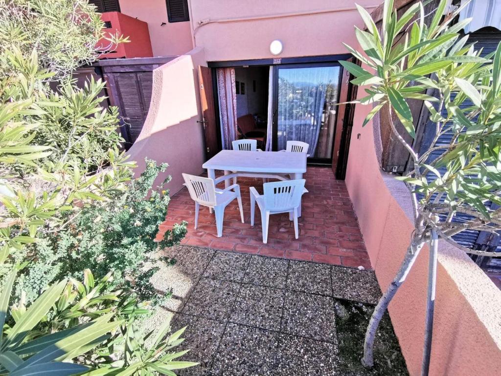 een patio met een tafel en stoelen in een huis bij Résidence MAISONS DE LA MER 2 - 2 Pièces pour 4 Personnes 94 in Port Leucate