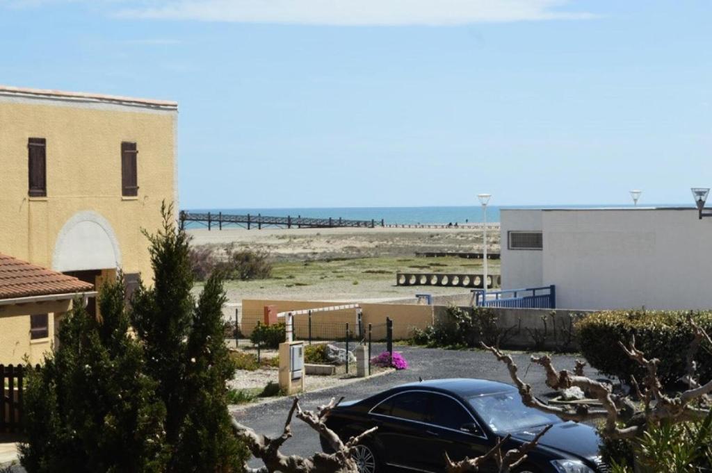 une voiture garée dans un parking près de la plage dans l'établissement Résidence Belle Plage - 2 Pièces 5 couchages PORT LEUCATE. Réf: 3BP_15D MAE-5544, à Port-Leucate