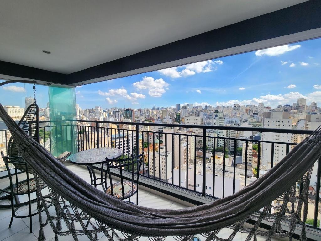 - un hamac sur un balcon avec vue sur la ville dans l'établissement FLAT COM VISTA INCRIVEL EM CONDOMINIO DE LUXO, à São Paulo