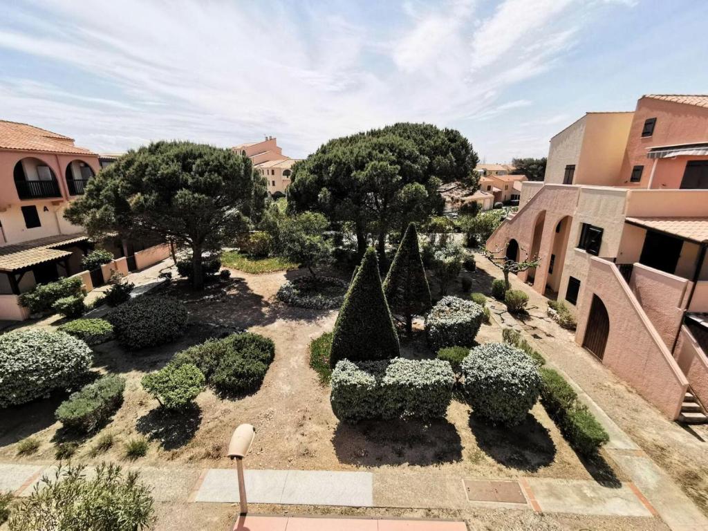 Elle offre une vue sur un jardin avec des arbres et des buissons. dans l'établissement Résidence MAISONS DES SABLES 4 - 2 Pièces pour 6 Personnes 44, à Port-Leucate