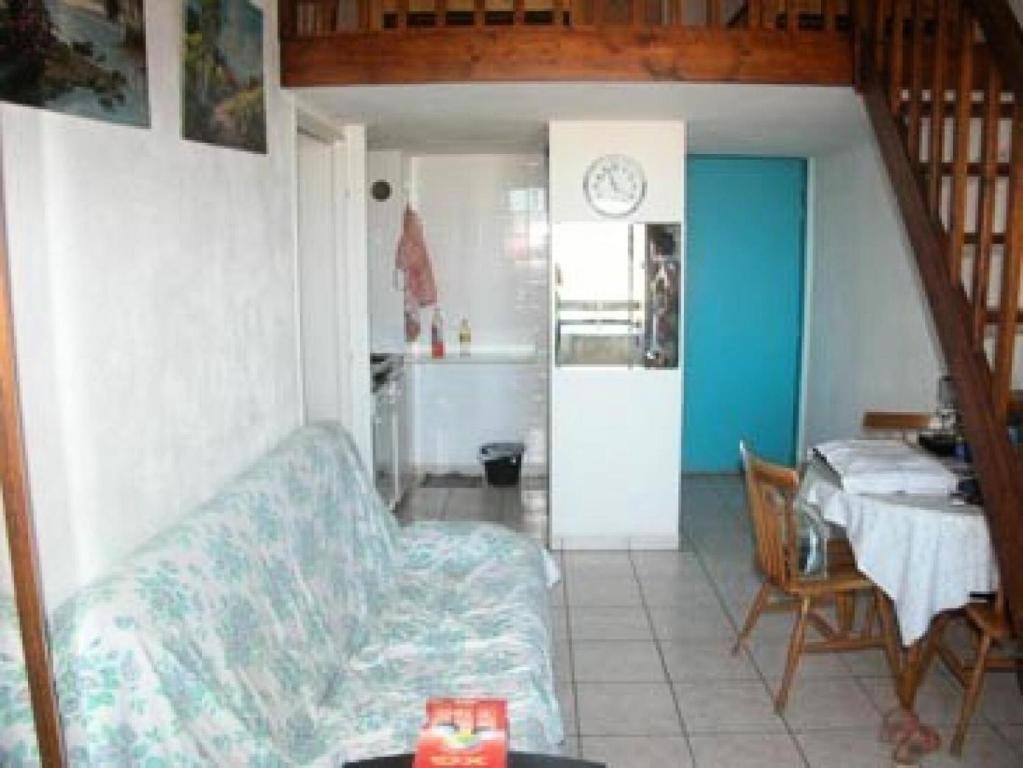 ein Wohnzimmer mit einem Sofa und einem Tisch sowie eine Küche in der Unterkunft Résidence MARINAS PORT ROSE 3 - 2 Pièces pour 6 Personnes 24 in Port Leucate