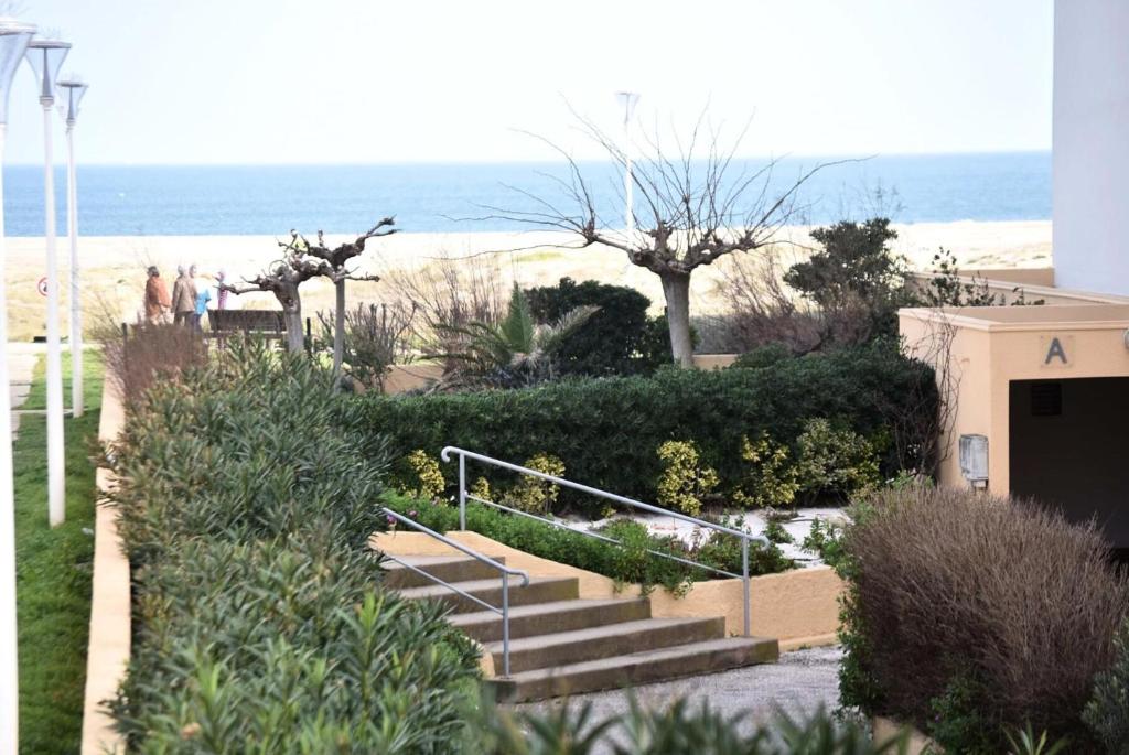 un groupe de personnes marchant par des escaliers près de la plage dans l'établissement Résidence Le Neptune - 2 Pièces pour 5 Personnes 64, à Port-Leucate