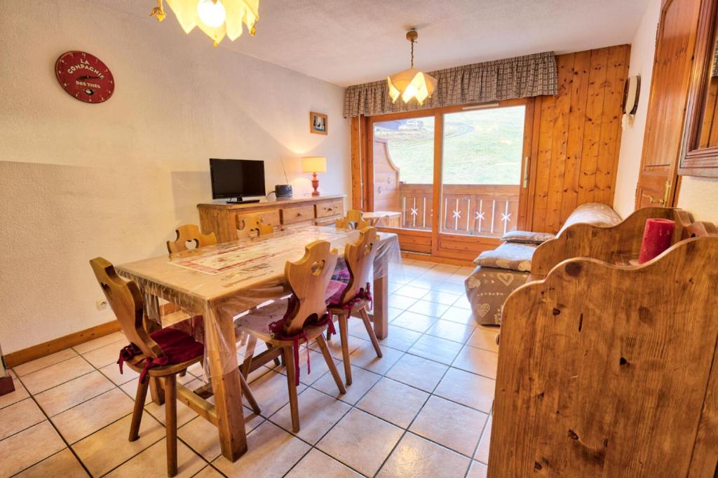 une salle à manger avec une table et des chaises en bois dans l'établissement Résidence Le Schuss 1 - Appartement sur le front de neige des Evettes MAE-2734, à Notre-Dame-de-Bellecombe