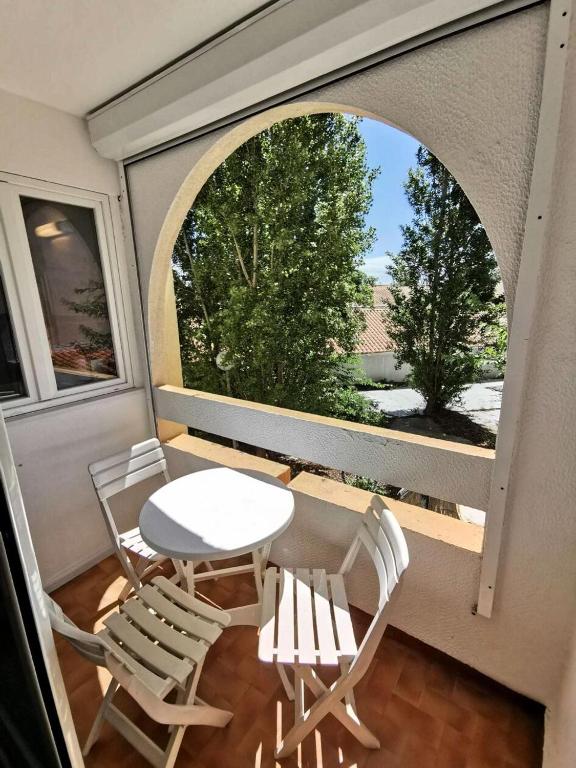 une pièce avec une table et des chaises sur un balcon dans l'établissement Résidence Les Arcades - 2 Pièces 4 couchages PORT LEUCATE MAE-5874, à Port-Leucate