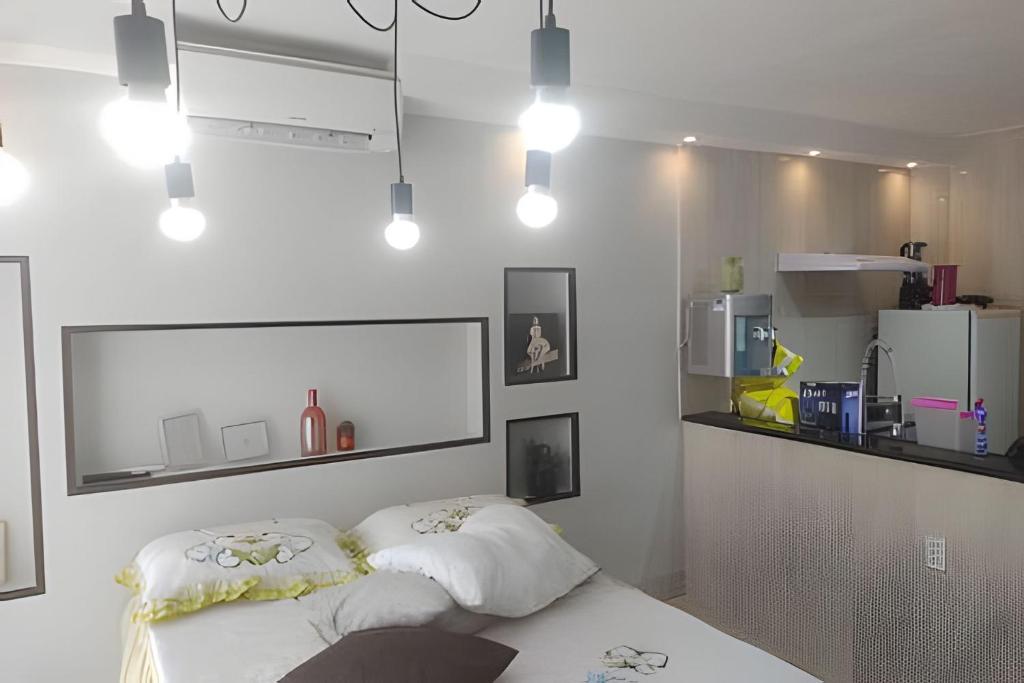 a white room with a bed and some lights at Edificio multishopping centro do Nucleo Bandeirante in Núcleo Bandeirante