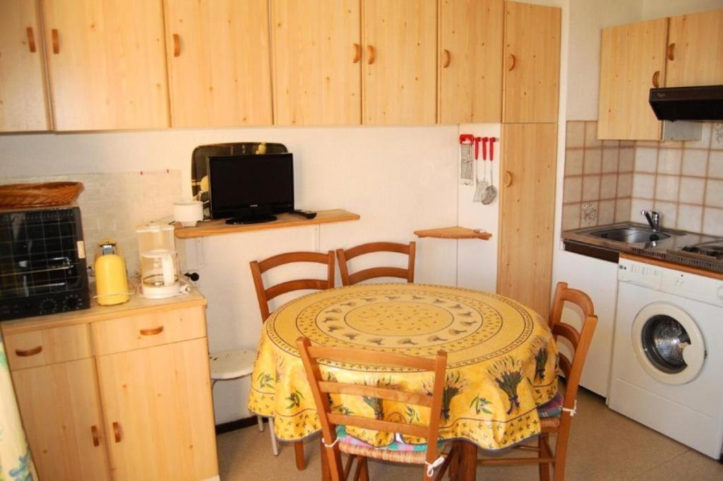 a small kitchen with a table and chairs and a sink at Résidence BELLE PLAGE - 2 Pièces pour 4 Personnes 44 in Port Leucate