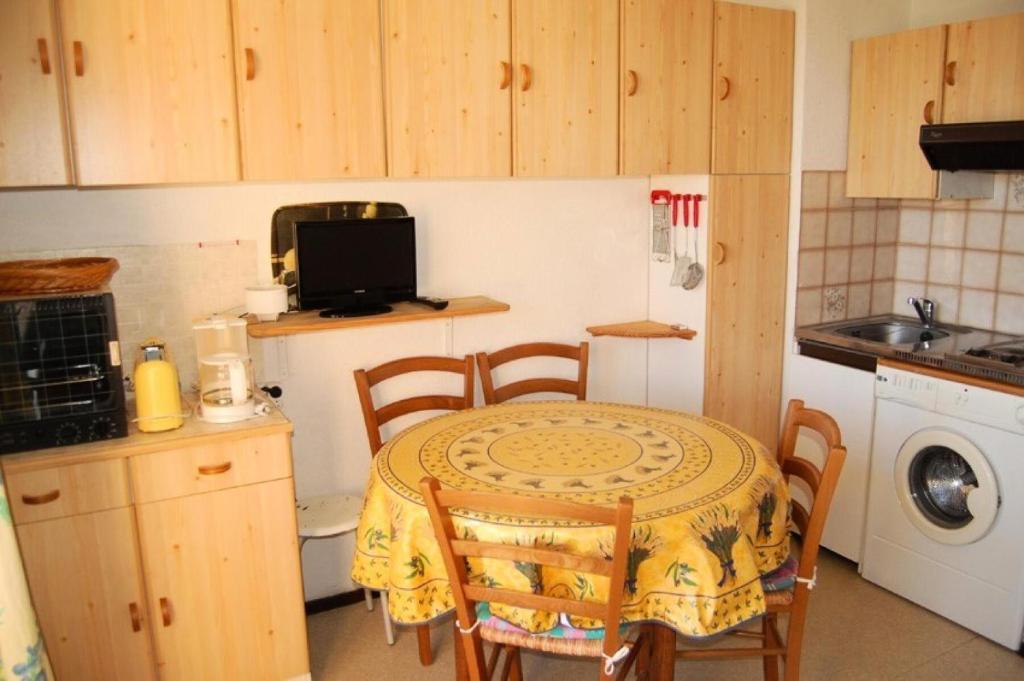 une petite cuisine avec une table, des chaises et un évier dans l'établissement Résidence Belle Plage - 2 Pièces 4 couchages PORT LEUCATE. Réf: 3BP_26A MAE-5844, à Port-Leucate