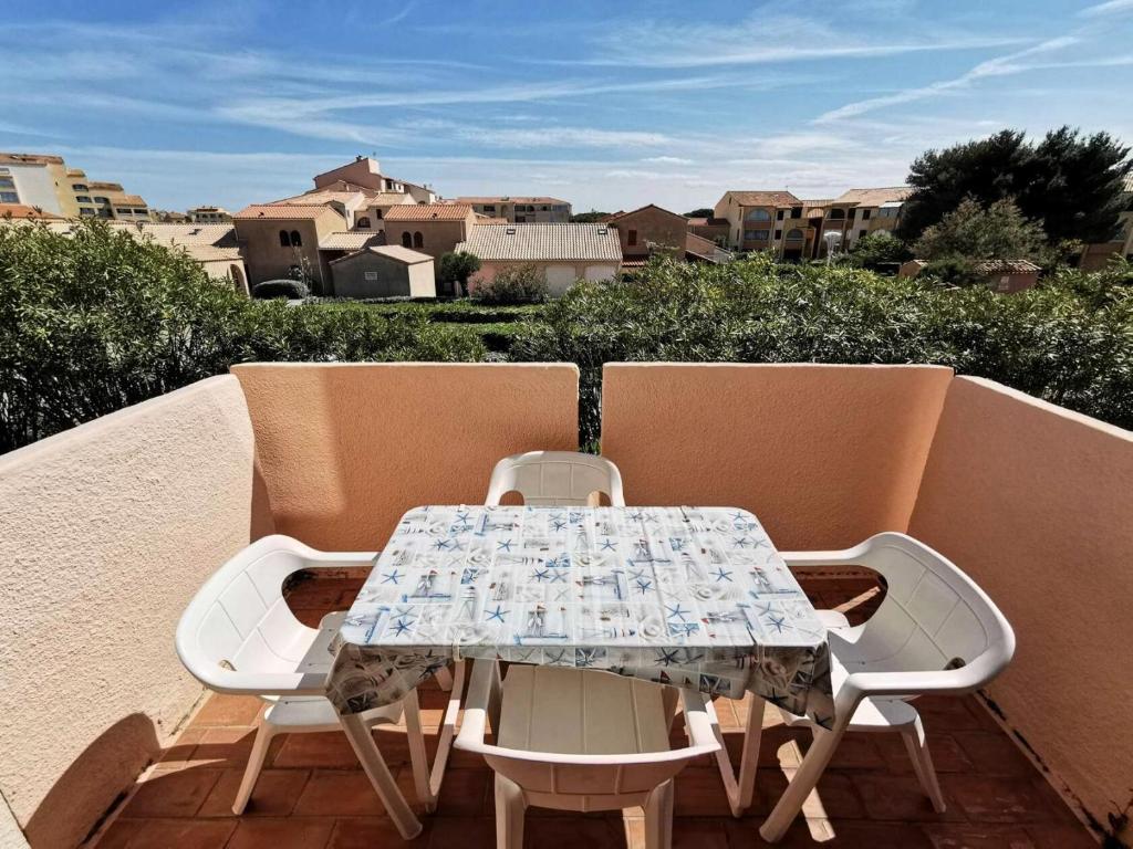 une table et deux chaises sur un balcon dans l'établissement Résidence Maisons Des Sables 4 - 2 Pièces 4 couchages PORT LEUCATE. Réf: 2MS4_59E MAE-6014, à Port-Leucate