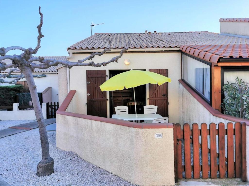 a yellow umbrella sitting on top of a house at Résidence Maisons De La Plage - VILLA T2 MEZZANINE 6 couchages PORT LEUCATE. Réf: 1MPL_95D MAE-6034 in Port Leucate