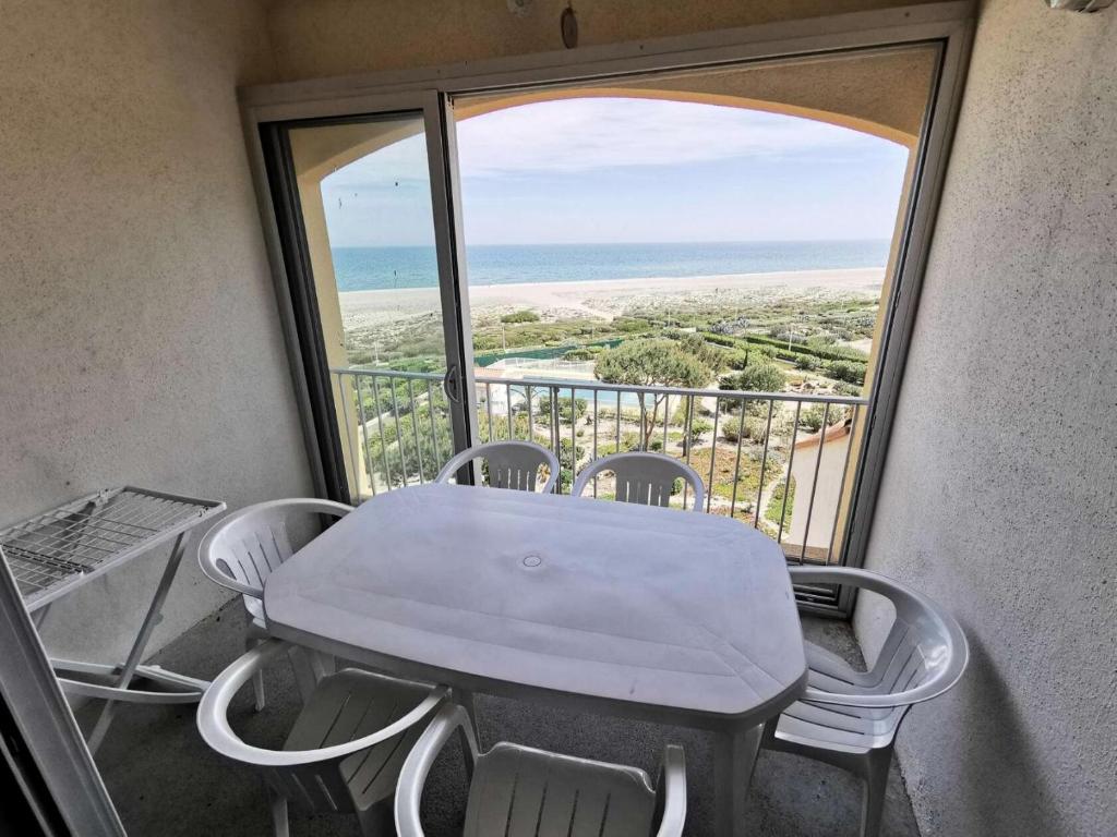 une table et des chaises dans une pièce avec vue sur l'océan dans l'établissement Résidence LES PLAGES D'ARGOS - 3 Pièces pour 6 Personnes 54, à Port-Leucate