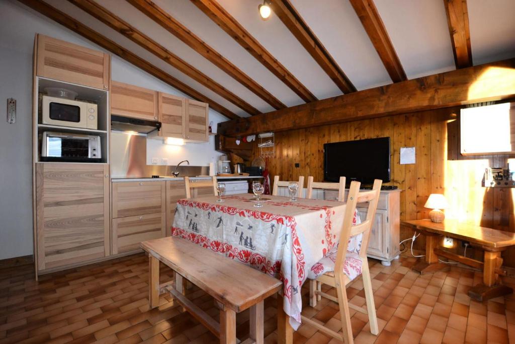 a kitchen and dining room with a table and chairs at Résidence La Beguette - 2 Pièces pour 5 Personnes 44 in Notre-Dame-de-Bellecombe