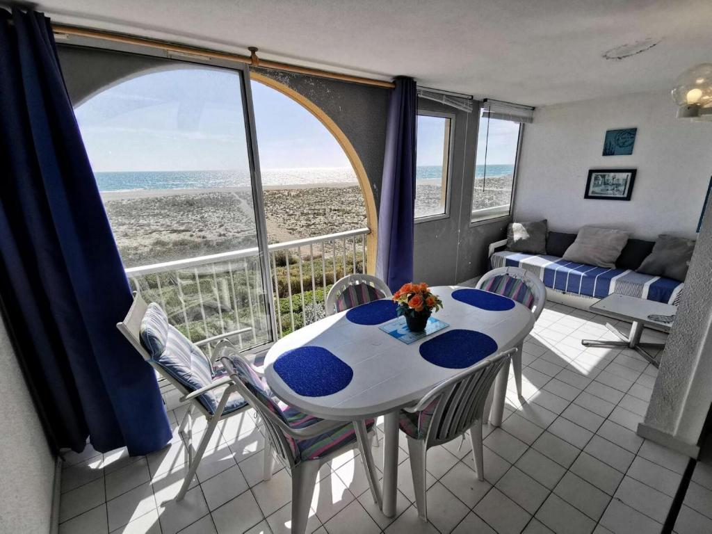 une table et des chaises dans une pièce avec vue sur l'océan dans l'établissement Résidence Copacabana - Appartement deux pièces pour 4 personnes avec très belle vue sur mer. Réf: 1COP_825H MAE-6224, à Port-Leucate