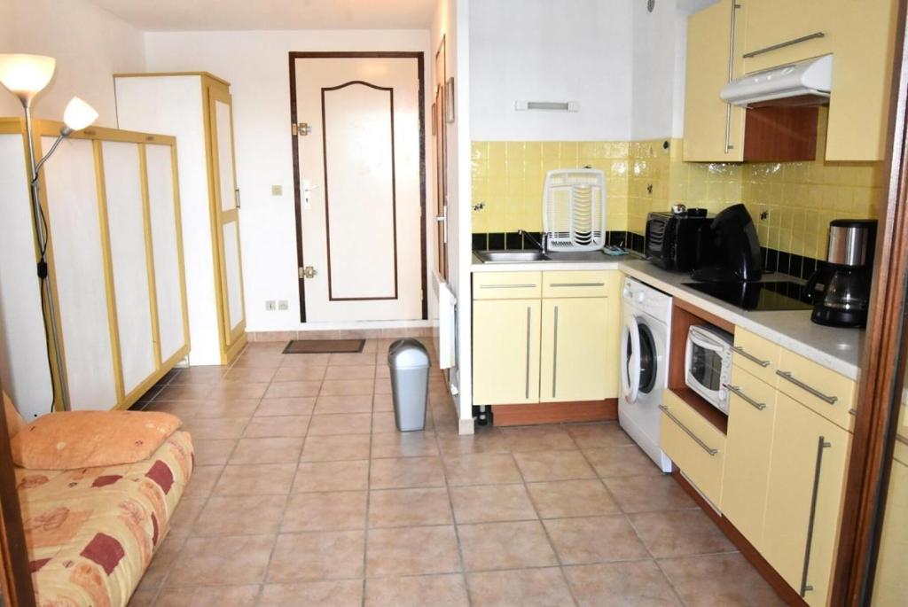 Il comprend une cuisine avec des placards jaunes et du carrelage. dans l'établissement Résidence Les Portes De La Mediterranee - STUDIO 2 PERSONNES 3 couchages PORT LEUCATE MAE-6324, à Port-Leucate