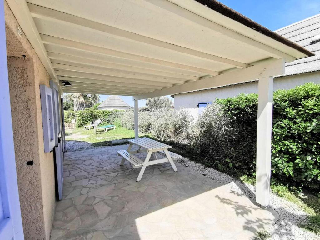 - une terrasse avec une table de pique-nique sous un auvent dans l'établissement Résidence Ile Des Pecheurs - VILLA TROIS PIECES 6 couchages LE BARCARES MAE-6764, à Port-Leucate