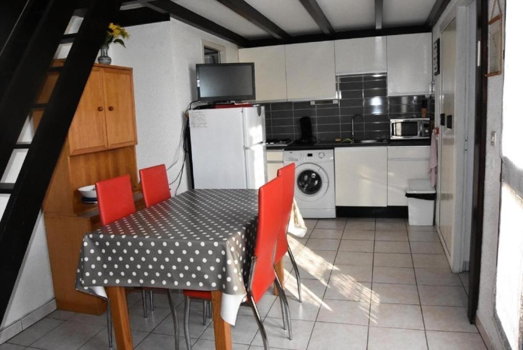 une cuisine avec une table, des chaises et un réfrigérateur dans l'établissement Résidence Equateur - APPT T2 CAB OU MEZZ 5 couchages PORT LEUCATE. Réf: 2MS3_32 MAE-7124, à Port-Leucate