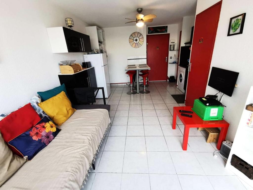 un salon avec un canapé et une cuisine dans l'établissement Résidence Copacabana - Coquet appartement deux pièces avec terrasse à Port Leucate. Réf: 1COP_101A MAE-6824, à Port-Leucate