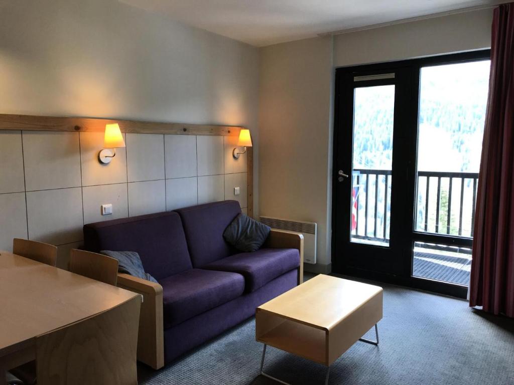 un salon avec un canapé violet et une table dans l'établissement Residence De La Foret - Appartement lumineux · Proche des pistes · Balcon MAE-5774, à Flaine