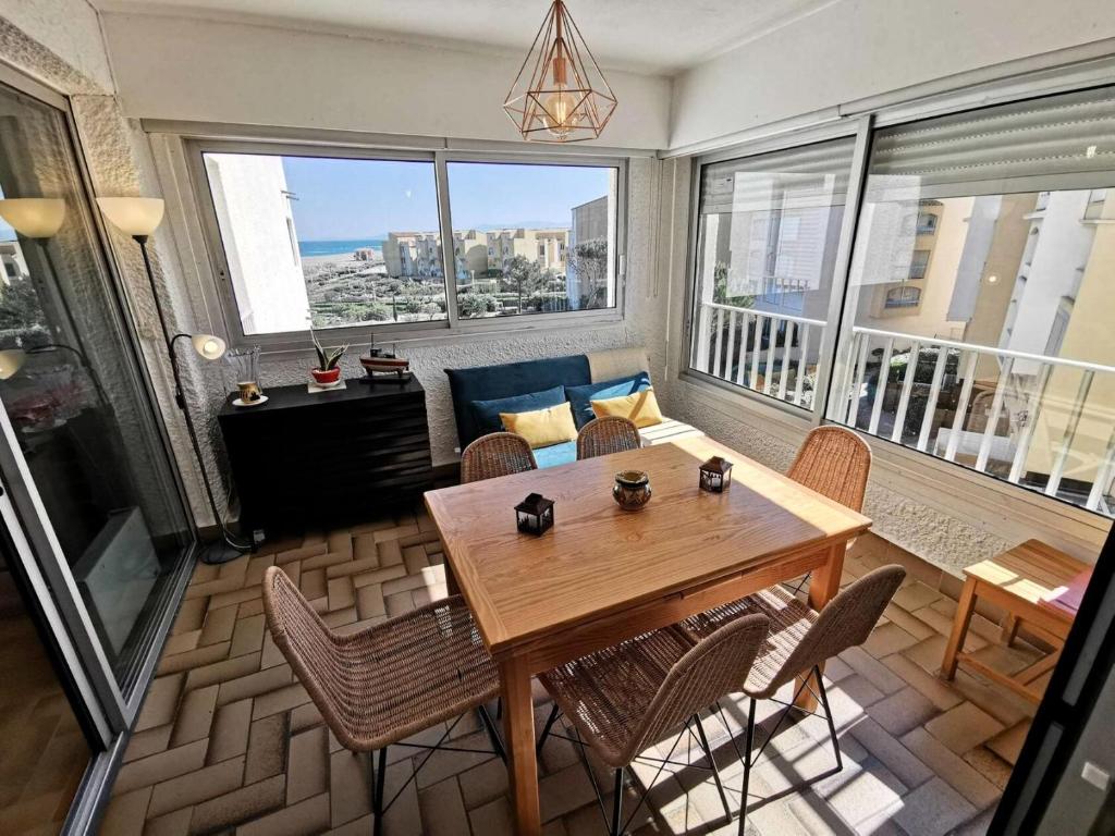 un salon avec une table et des chaises en bois dans l'établissement Résidence Les Cyclades - 2 Pièces 4 couchages PORT LEUCATE. Réf: 2CYC_37A MAE-7234, à Port-Leucate