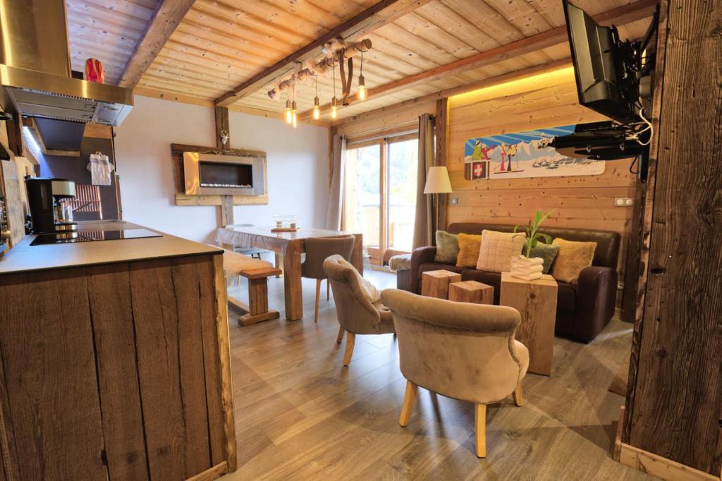 uma sala de estar com uma cozinha e uma sala de estar com um sofá em Chalet La Chalee - 5 Pièces pour 8 Personnes 64 em Notre-Dame-de-Bellecombe
