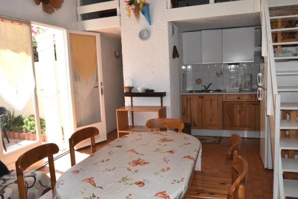 une cuisine et une salle à manger avec une table et des chaises dans l'établissement Résidence Les Leucatines 1 - VILLA T2 MEZZANINE 6 couchages PORT LEUCATE MAE-7184, à Port-Leucate