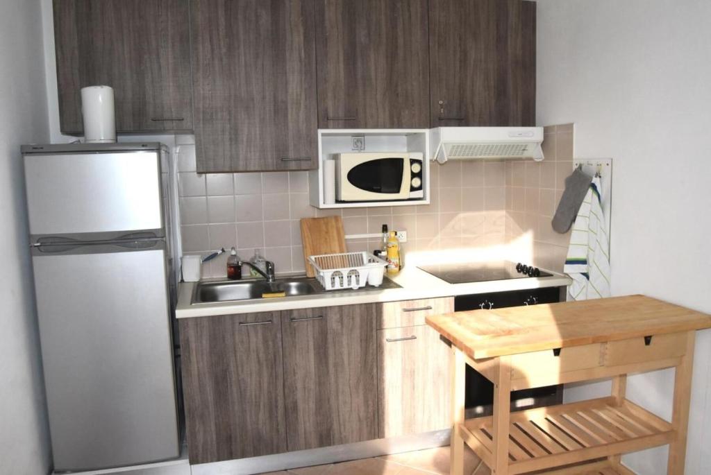 una pequeña cocina con nevera blanca y mesa en Résidence LES CANDEILLERES - Maisons & Villas pour 6 Personnes 94, en Port Leucate