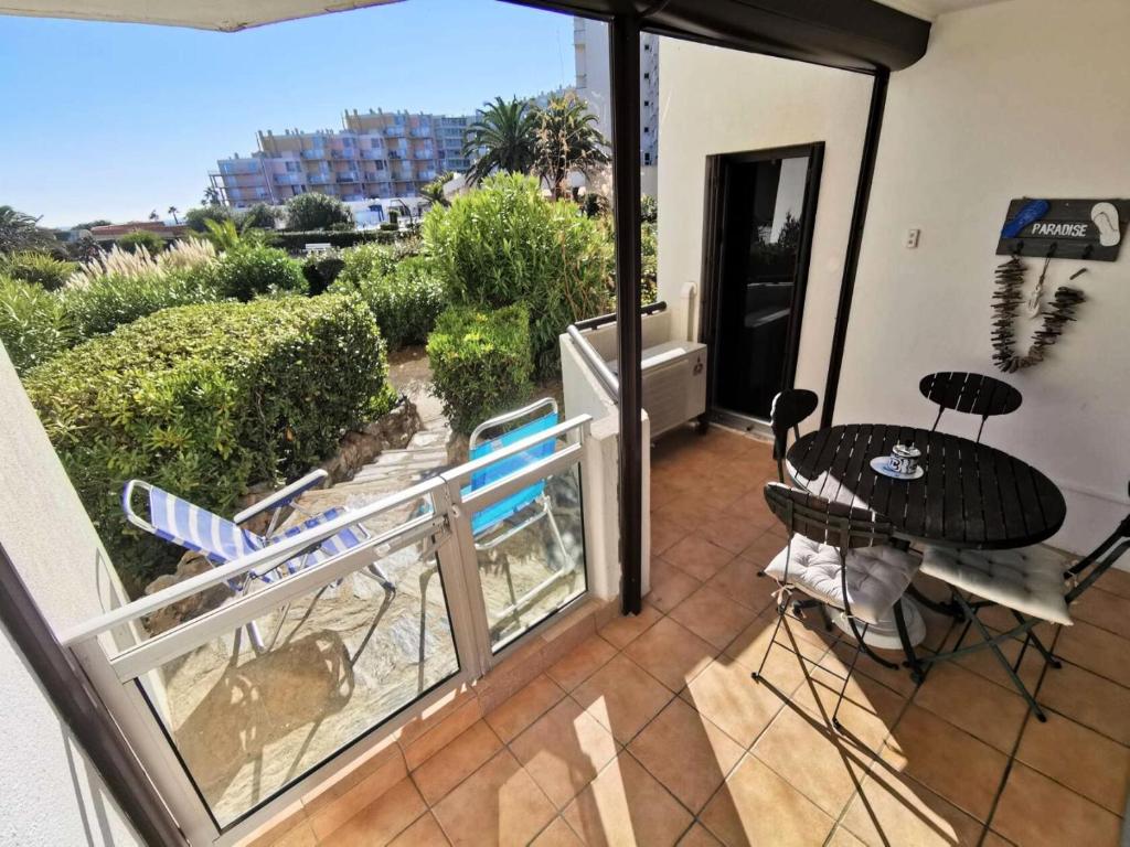 un patio avec une table et des chaises sur un balcon dans l'établissement Résidence Soleil Levant 1 - 2 Pièces 4 couchages LE BARCARES MAE-8114, à Port-Leucate