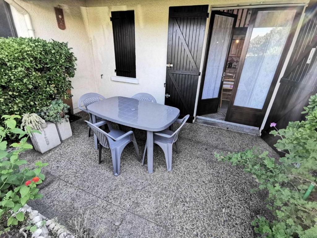 une table et des chaises devant une maison dans l'établissement Résidence Village Merlin - VILLA T2 MEZZANINE 4 couchages PORT LEUCATE MAE-6954, à Port-Leucate