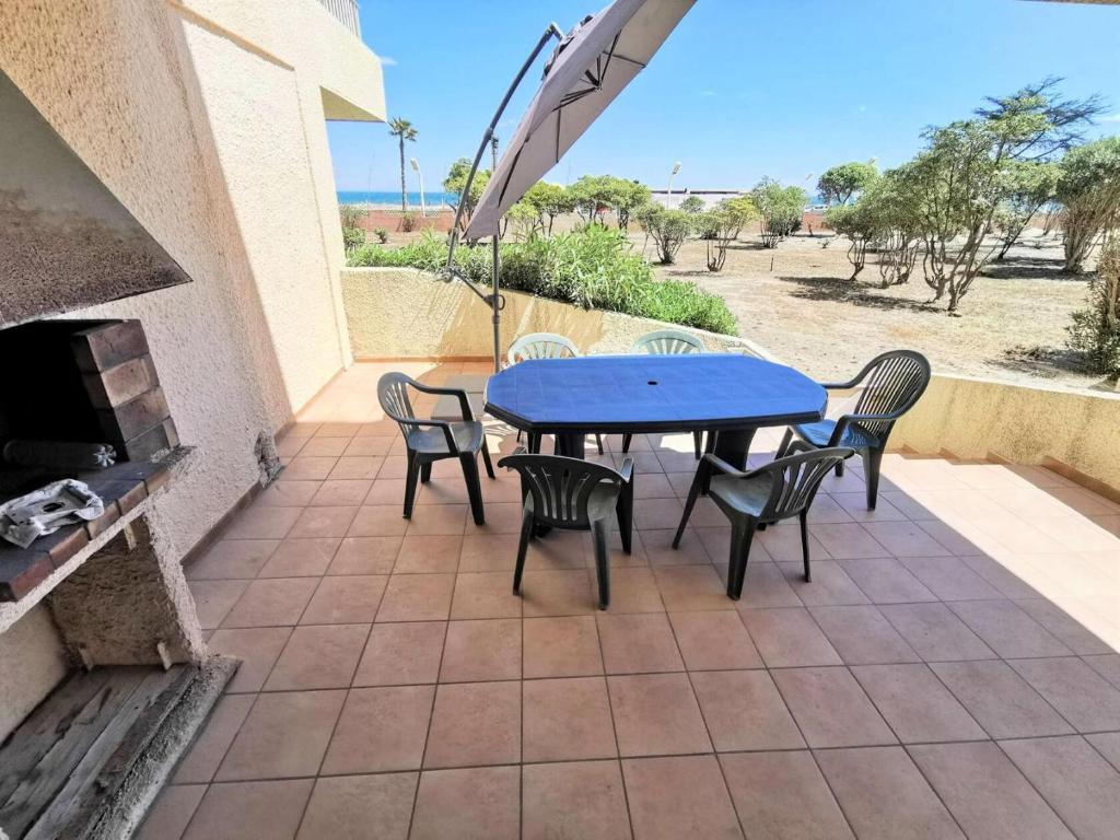 une table bleue et des chaises sur une terrasse avec une cheminée dans l'établissement Résidence La Sardane - 2 Pièces 5 couchages LE BARCARES MAE-2404, au Barcarès
