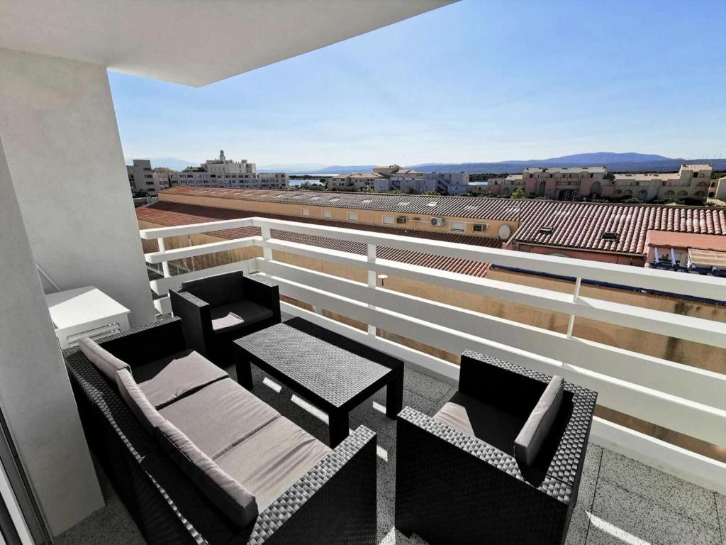 d'un balcon avec des chaises et des tables offrant une vue sur un stade. dans l'établissement Résidence Les Voiles Blanches - 2 Pièces 4 couchages PORT LEUCATE MAE-5854, à Leucate