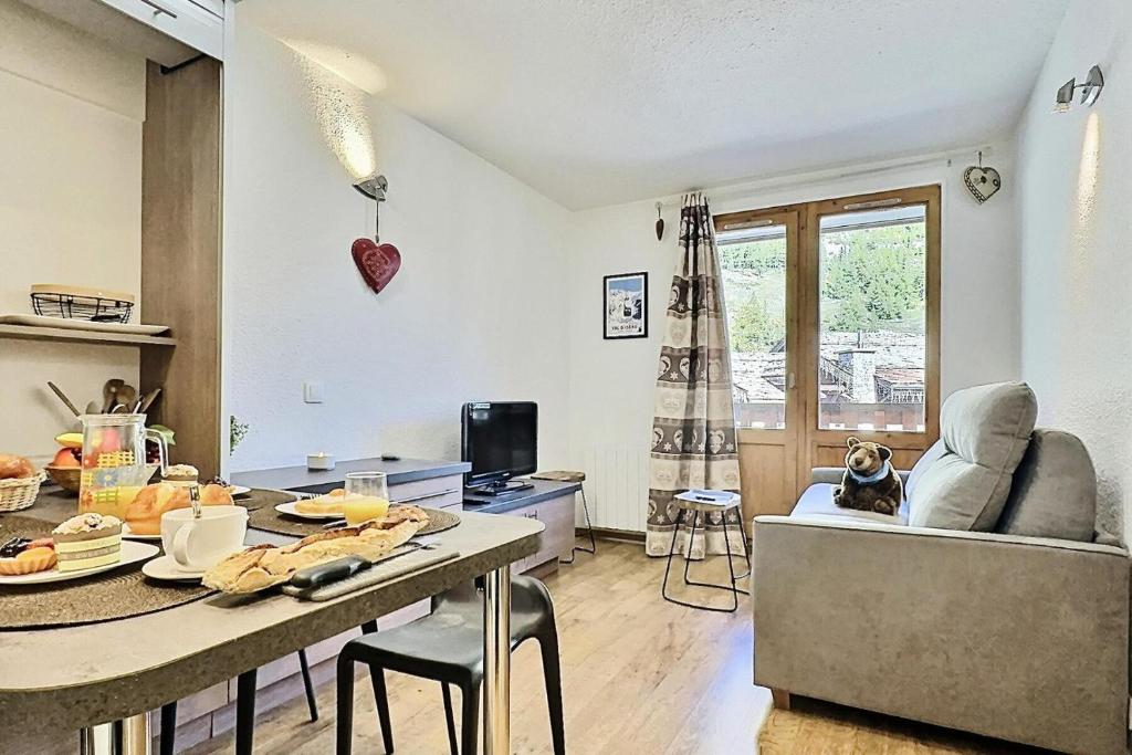 une cuisine et un salon avec une table et un canapé dans l'établissement Résidence Les Jardins De Val - Agréable studio cabine complètement rénové pour 4 personnes situé à Val d'isère à 350m du centre du village et 450m des pistes MAE-0164, à Val dʼIsère