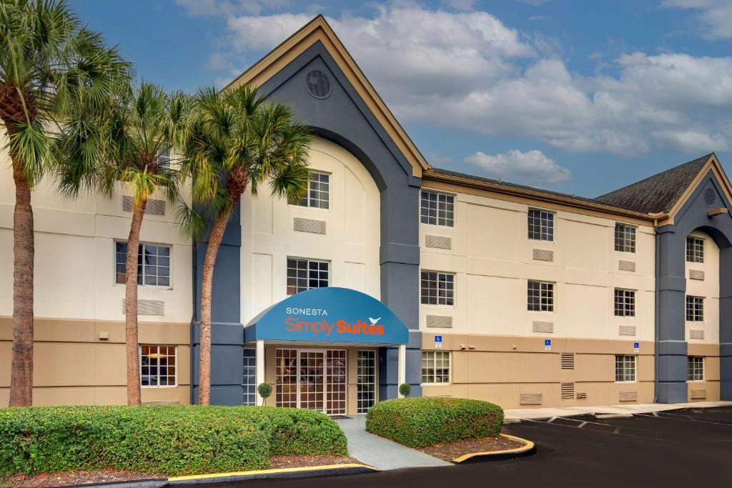 un hotel con palmeras frente a un edificio en Sonesta Simply Suites Miami Airport Doral en Miami