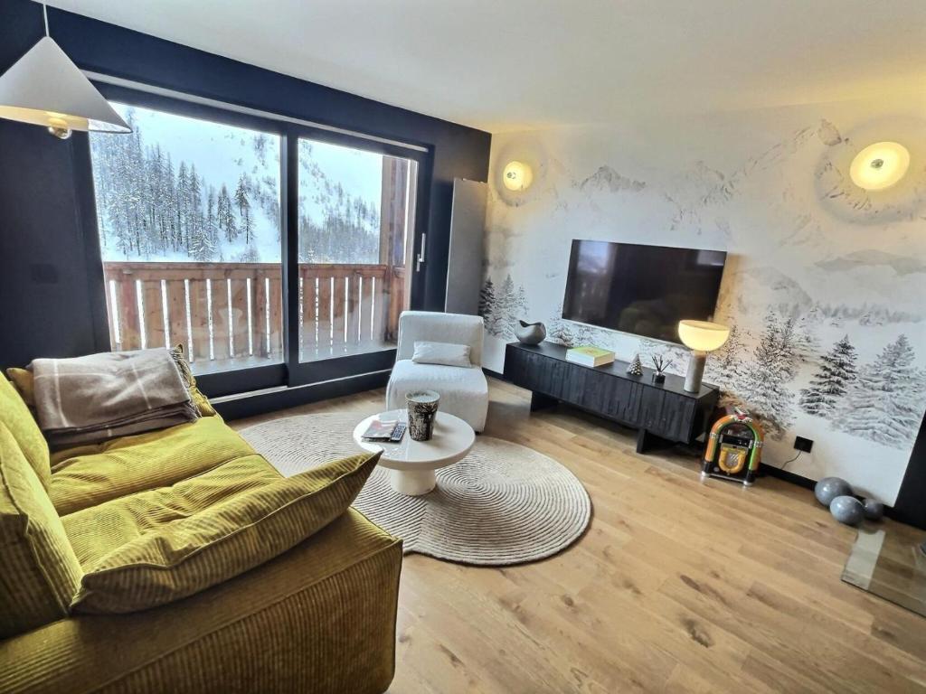 un salon avec un canapé et une télévision dans l'établissement Chalet Du Jardin Alpin Ii - Charmant 3 pièces pour 4 à 5 personnes, situé à Val d'Isère dans le quartier La Legettaz au pied des pistes MAE-2794, à Val dʼIsère
