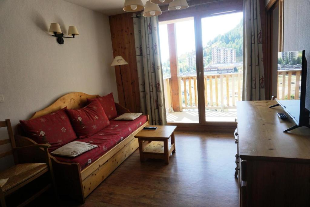 - un salon avec un canapé rouge et une grande fenêtre dans l'établissement Résidence Terrasses De La Bergerie - 3 pièces 6 personnes MAE-5944, à Orcières