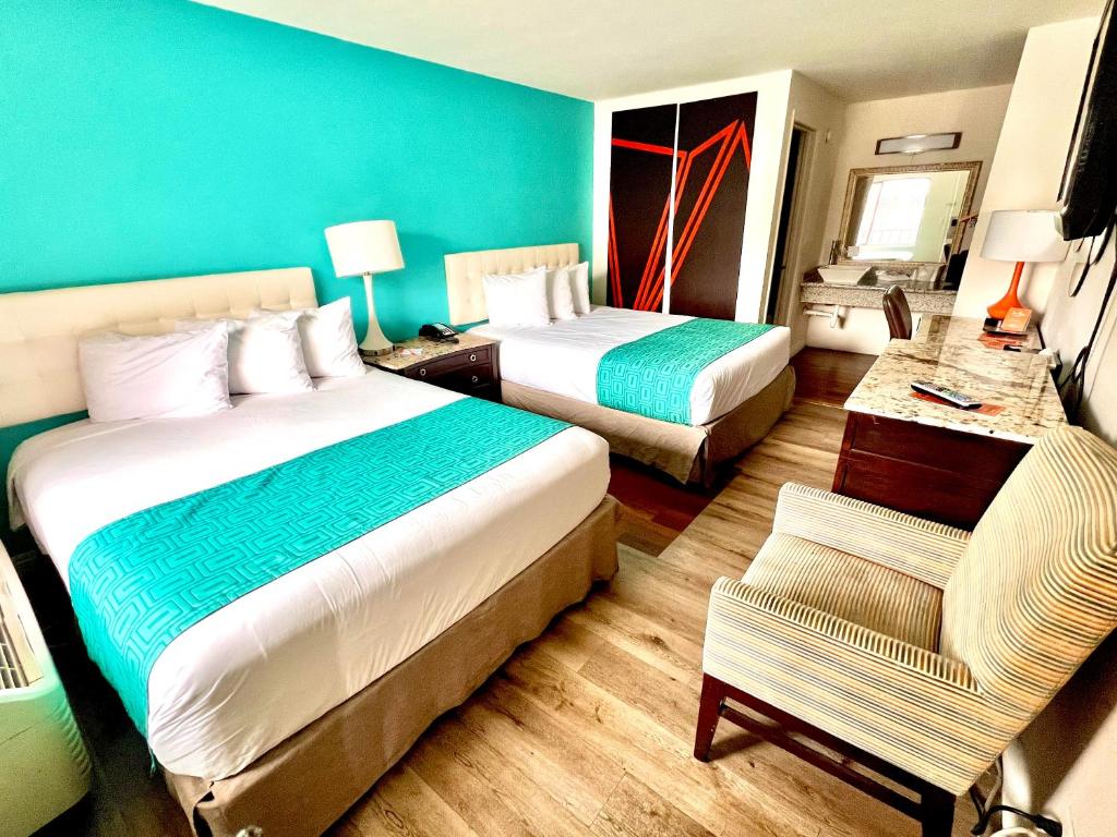 um quarto de hotel com duas camas e uma cadeira em Howard Johnson by Wyndham Downtown Reno em Reno