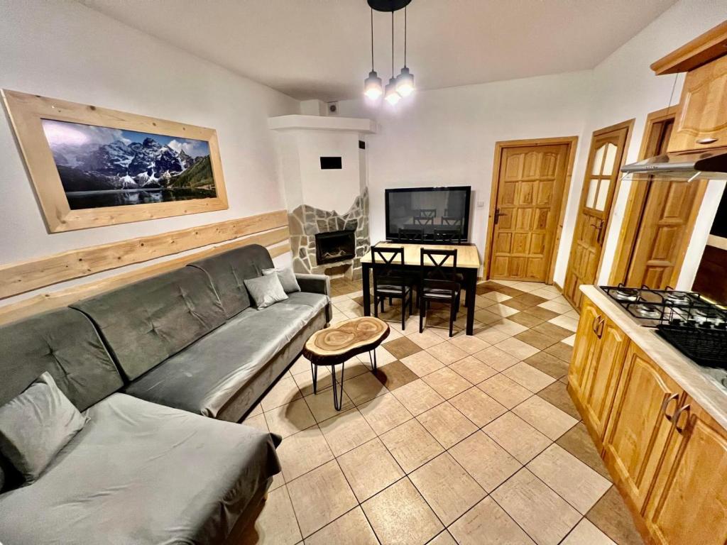 a living room with a couch and a table at Apartamenty Nad Dunajcem koło Zakopanego in Biały Dunajec