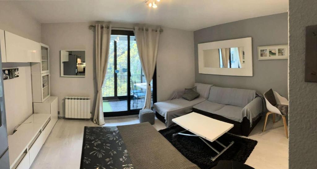 un salon avec un canapé et une table dans l'établissement Résidence Luberon Loisir - Appartement Front du Lac et Verdure dans Domaine avec Piscine et Tennis MAE-8834, à Six-Fours-les-Plages