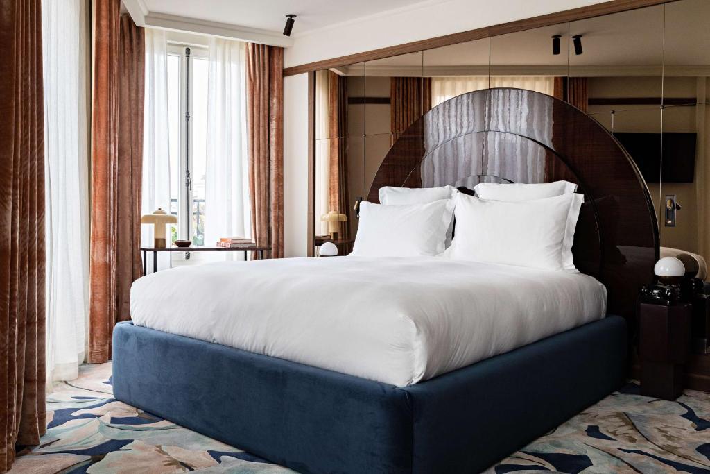 a bedroom with a large bed with a wooden headboard at Hotel Florida Paris in Paris
