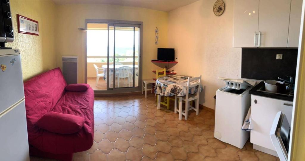 un salon avec un canapé rouge et une cuisine dans l'établissement Résidence Marines D'aryana - Appartement front de mer avec tennis et piscine MAE-9174, à Six-Fours-les-Plages
