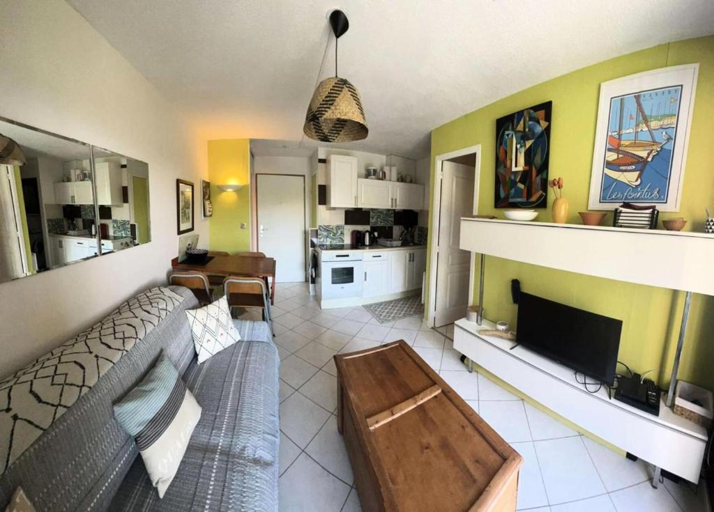 un salon avec un canapé et une télévision dans l'établissement Résidence Cap Vert - APPARTEMENT FRONT DE MER DANS DOMAINE AVEC PISCINE ET TENNIS MAE-8984, à Six-Fours-les-Plages