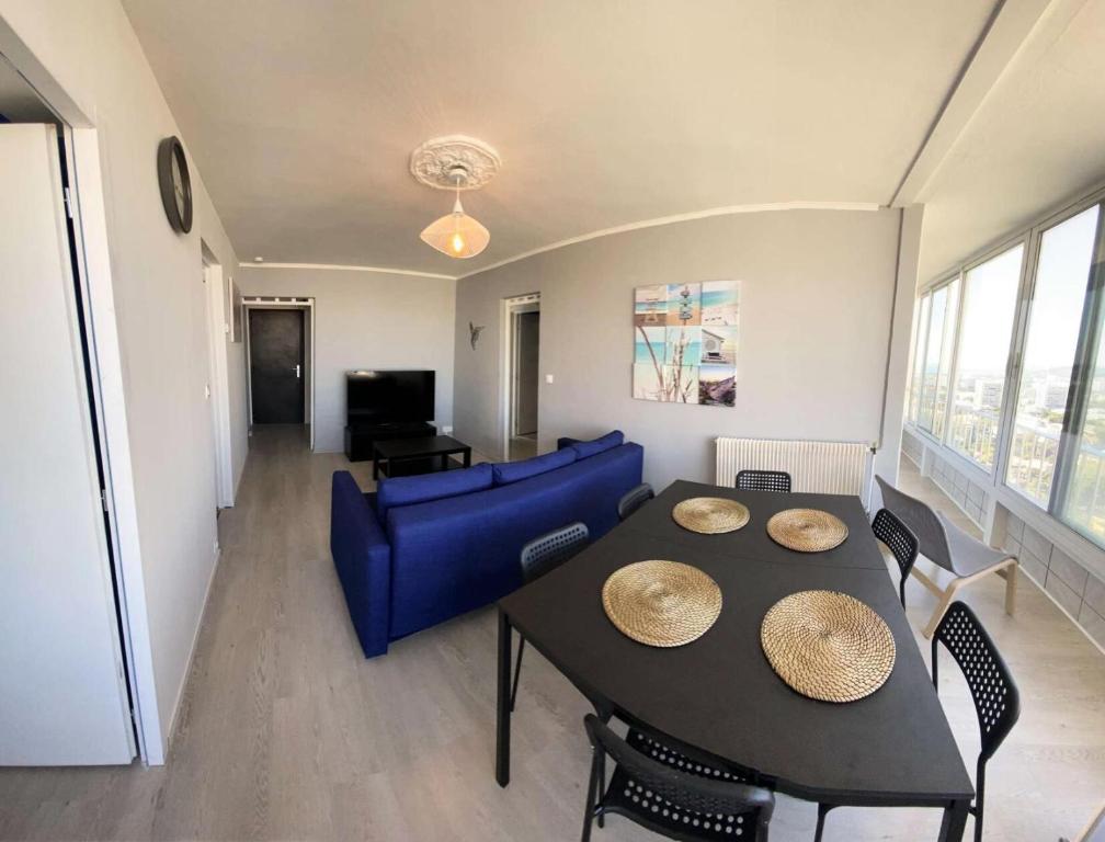 un salon avec une table et un canapé bleu dans l'établissement Résidence Rouviere - Grand appartement Vue Mer Budget Maitrisé MAE-9664, à Marseille